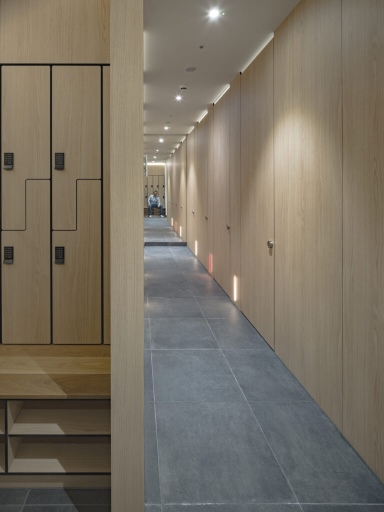 Locker corridor at YY London's changing facilities, with timber cabinetry along both sides