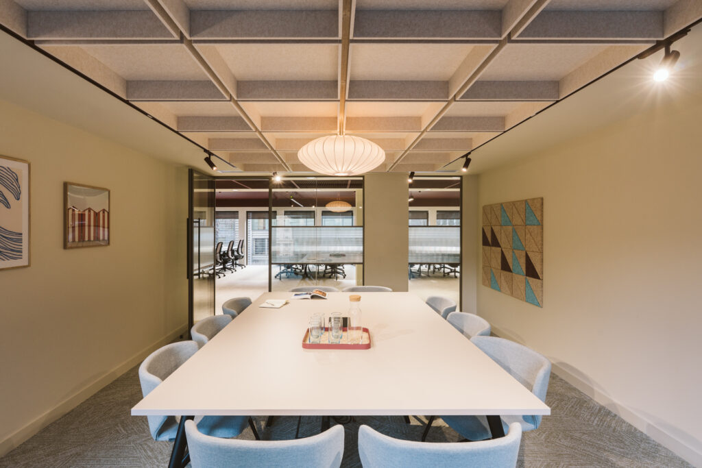 Meeting room at Cannon Green with an acoustic timber ceiling grid, pendant light and artwork