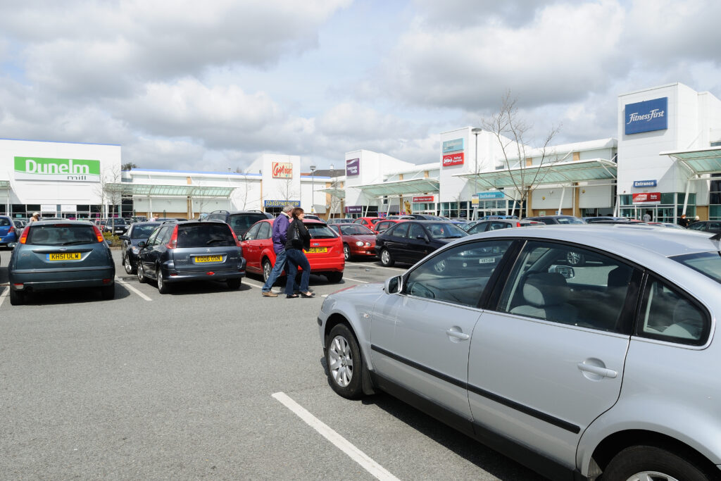 Turner Rise Retail Park car park with the Dunelm and Fitness First units and shoppers crossing