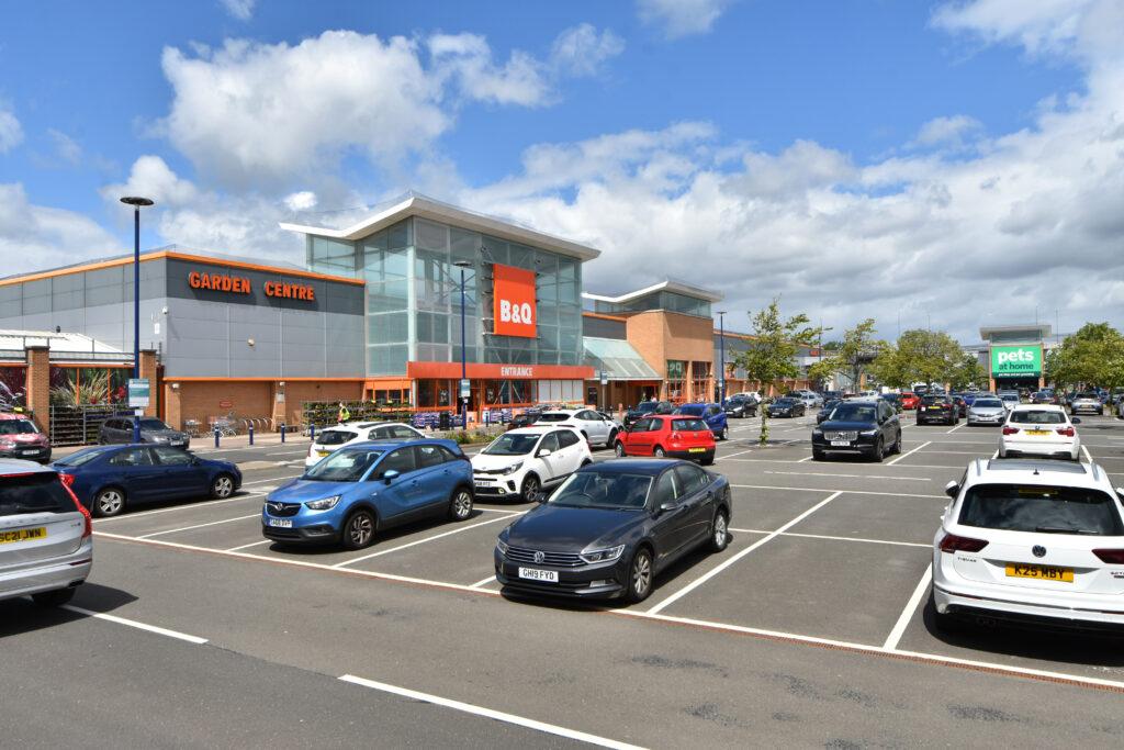 B&Q store entrance and garden centre at Abbotsinch Shopping Park, with cars parked in the foreground