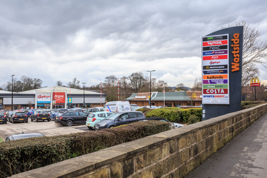 Westside Shopping Park entrance sign listing tenants including Asda, TK Maxx, Next and Currys PC World