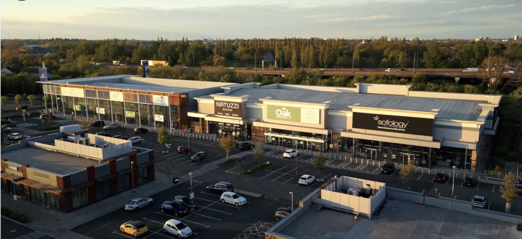 Aerial view of Gallagher Shopping Park at sunset, with Natuzzi, Oak Furnitureland and Sofology units