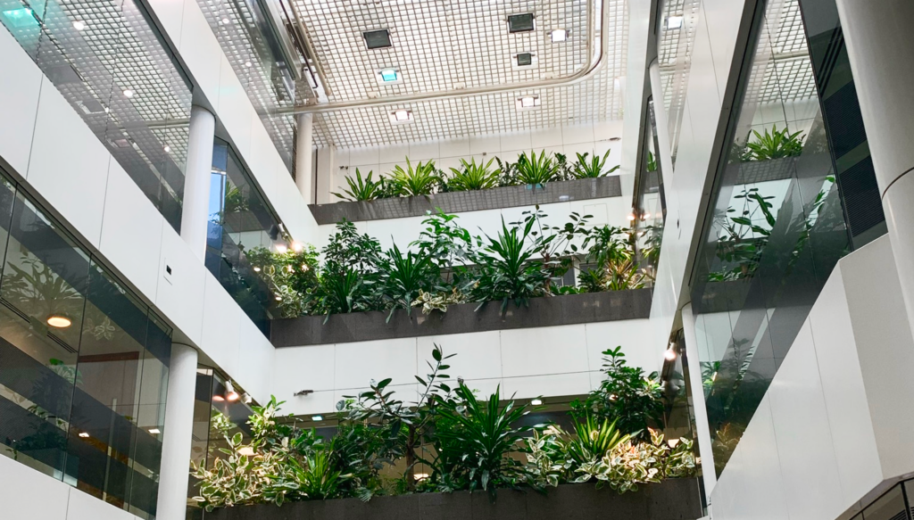 Plant-filled atrium inside Pinners Hall, London, with tiered greenery between the office floors