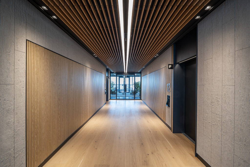 Lift lobby corridor at Osmo Nine Elms, with timber-slatted ceiling and oak flooring